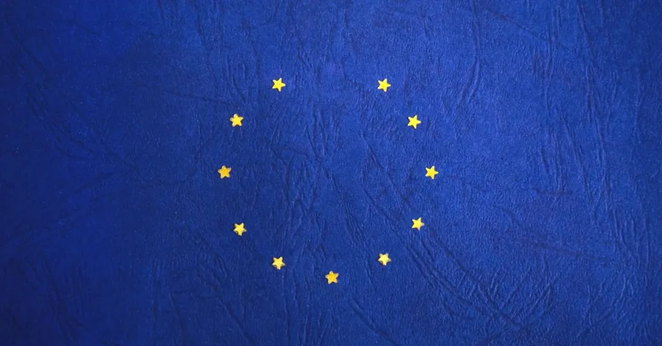 Drapeau européen superposé à une interface de chatbot symbolisant l'AI Act