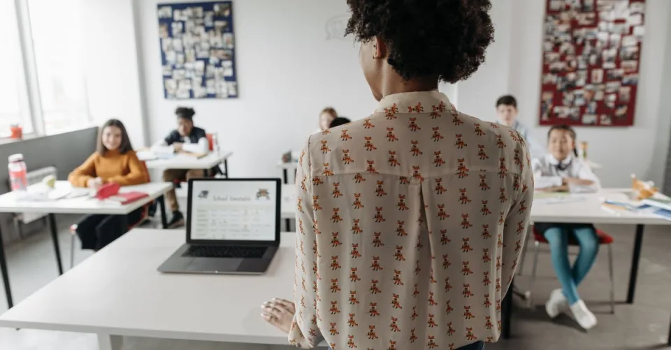 Enseignant utilisant un ordinateur portable avec un assistant IA en classe
